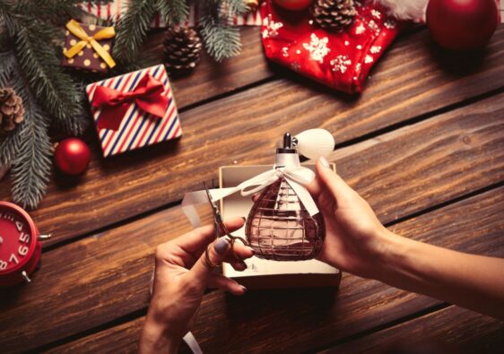 Kobieta pakuje jako prezent świąteczny prefumy